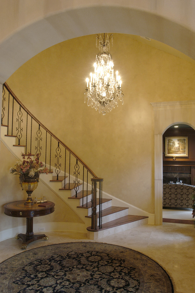 Large elegant wooden curved staircase photo in Baltimore with tile risers
