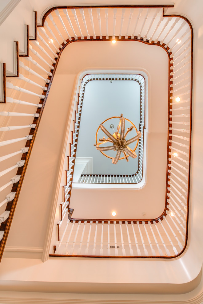 Пример оригинального дизайна: огромная п-образная лестница в классическом стиле с ступенями с ковровым покрытием, ковровыми подступенками и деревянными перилами
