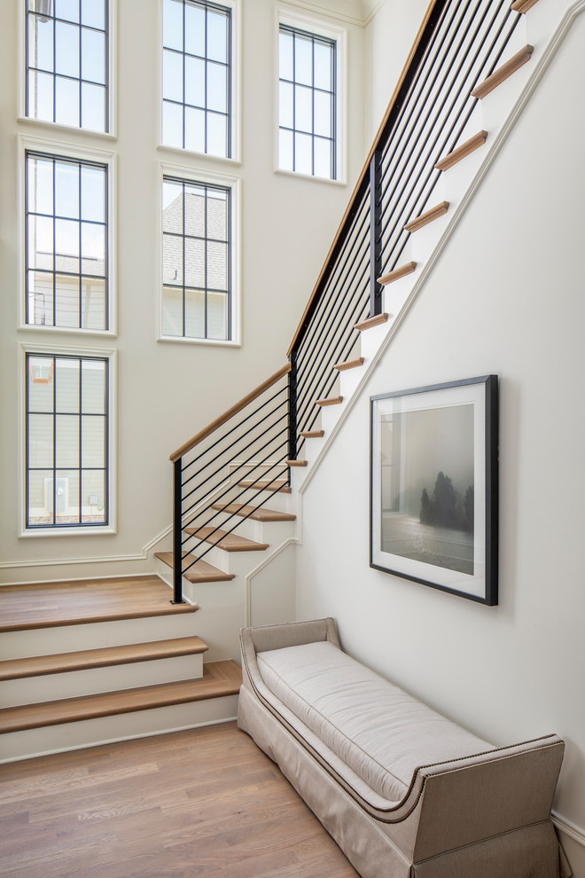 Idée de décoration pour un grand escalier peint tradition en U avec des marches en bois et un garde-corps en métal.