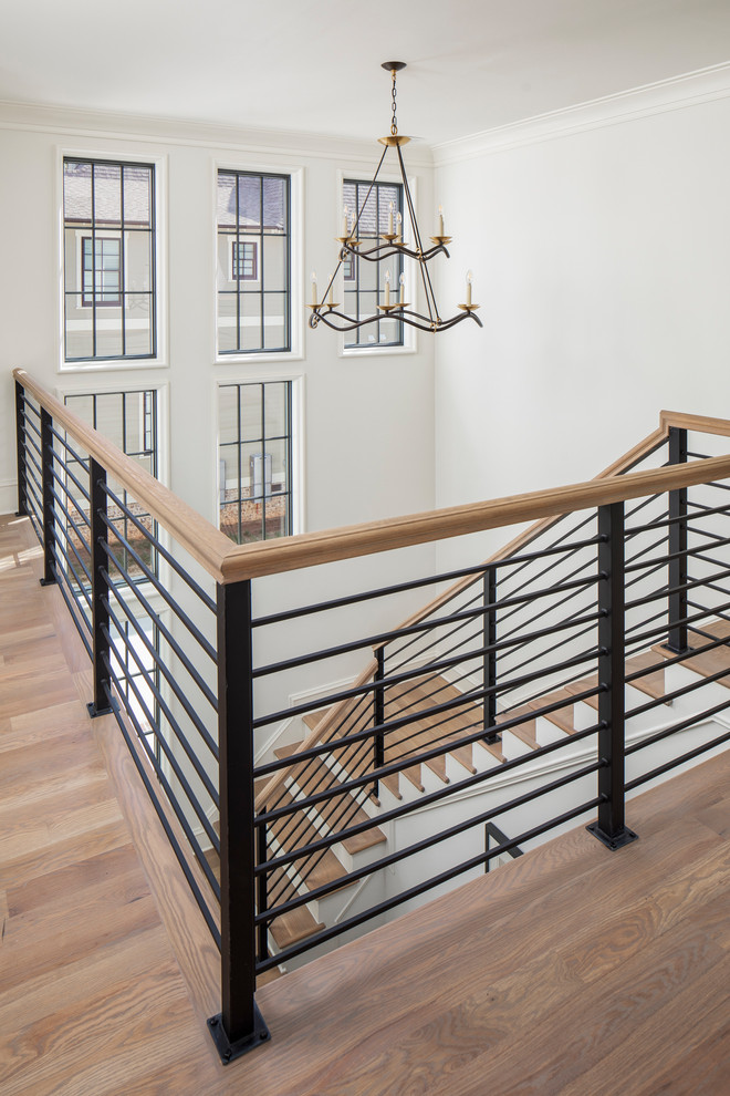Источник вдохновения для домашнего уюта: большая п-образная лестница в стиле неоклассика (современная классика) с деревянными ступенями, крашенными деревянными подступенками и металлическими перилами
