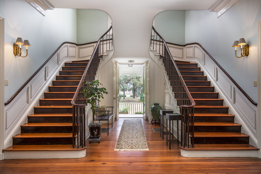 Large classic wood curved staircase in Charleston with wood risers.