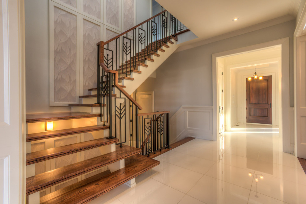 Свежая идея для дизайна: угловая лестница в стиле неоклассика (современная классика) с деревянными ступенями и металлическими перилами без подступенок - отличное фото интерьера