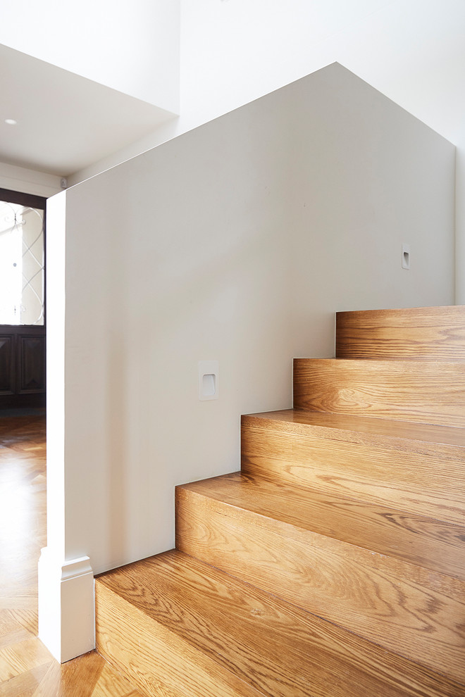 Exemple d'un grand escalier tendance en U avec des marches en bois, des contremarches en bois et un garde-corps en bois.