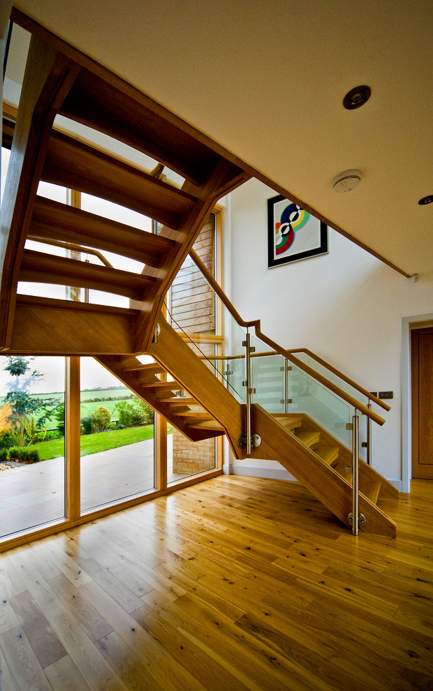 Ejemplo de escalera suspendida minimalista grande sin contrahuella con escalones de madera
