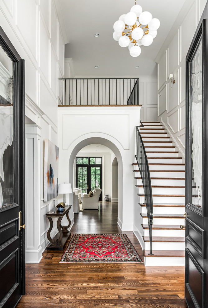 Inspiration for a large transitional wooden curved metal railing staircase remodel in Nashville with painted risers