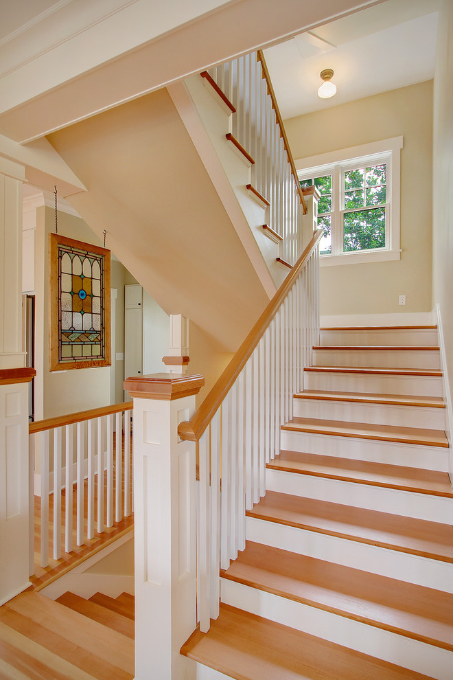 Imagen de escalera en U tradicional con escalones de madera y contrahuellas de madera pintada