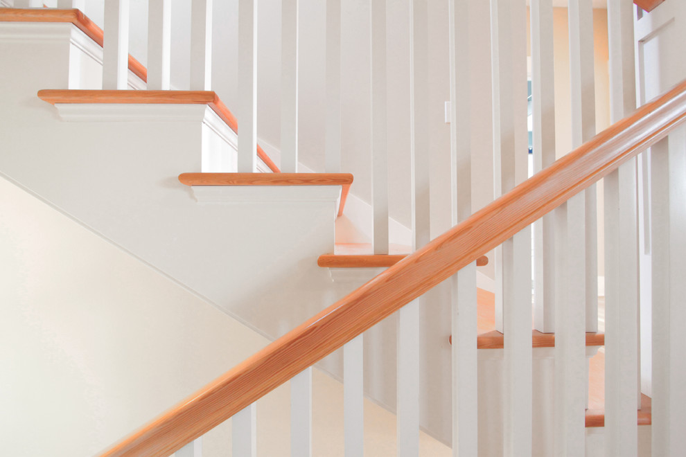 Diseño de escalera en U de estilo americano de tamaño medio con escalones de madera, contrahuellas de madera y barandilla de madera