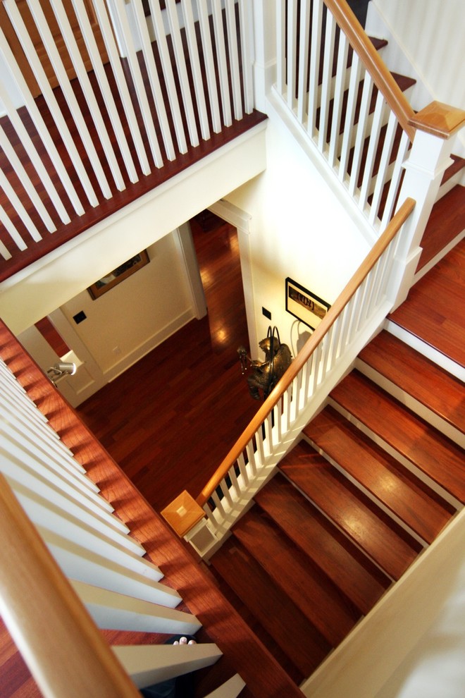 Imagen de escalera en U clásica grande con escalones de madera y contrahuellas de madera pintada