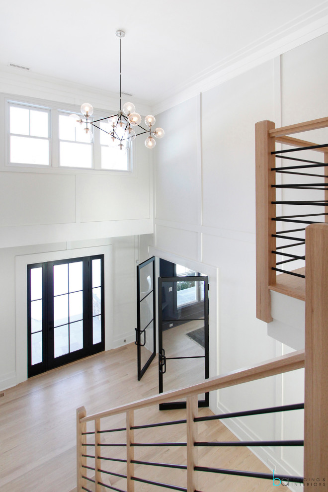 Large trendy wooden l-shaped mixed material railing and wall paneling staircase photo in New York with wooden risers