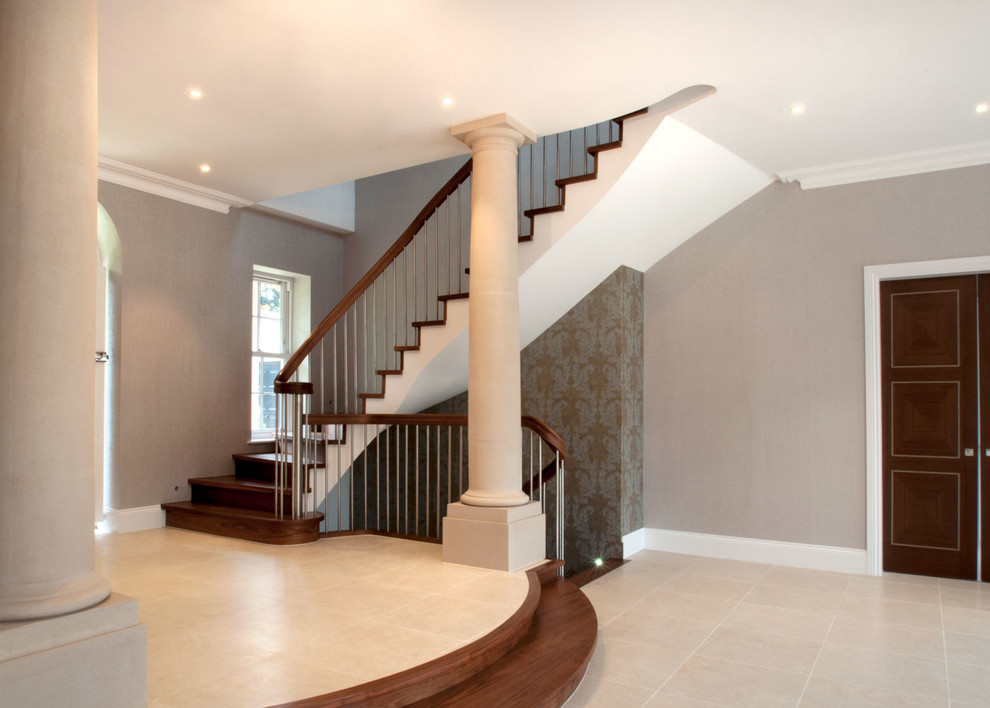 This is an example of a medium sized classic wood curved mixed railing staircase in Buckinghamshire with wood risers.