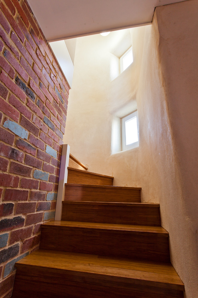 Imagen de escalera actual pequeña con escalones de madera y contrahuellas de madera