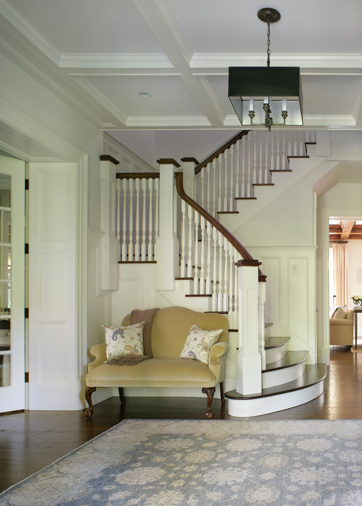 Photo of a large traditional wood u-shaped staircase in New York with wood risers.