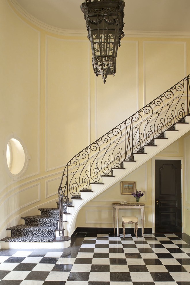 Diseño de escalera curva tradicional con escalones de madera y contrahuellas de madera pintada