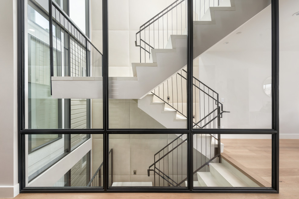 Пример оригинального дизайна: большая п-образная лестница в современном стиле с ступенями из известняка, подступенками из известняка и перилами из смешанных материалов