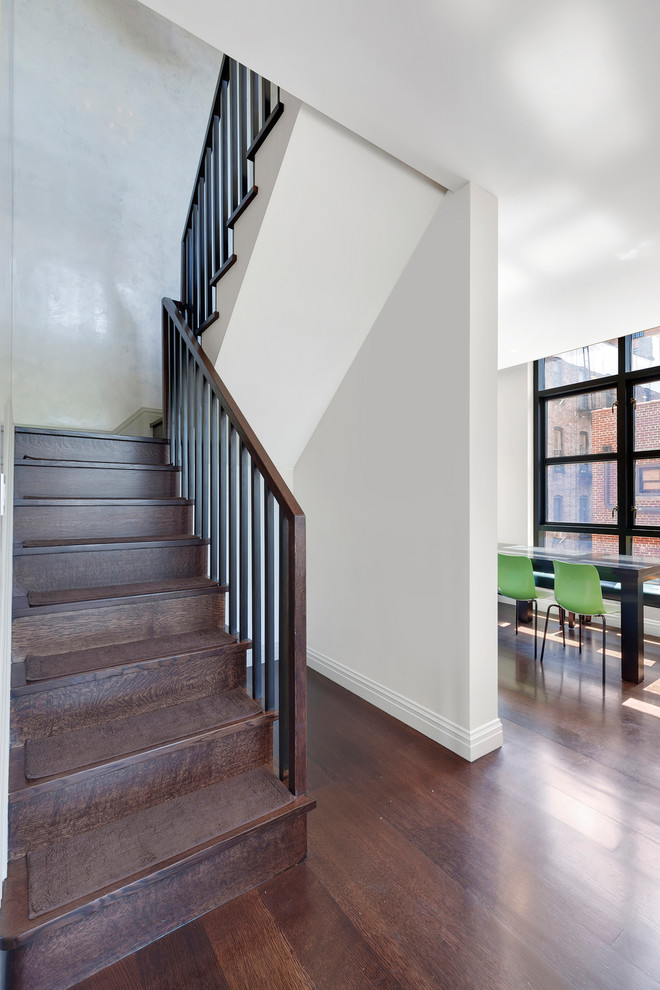 ニューヨークにあるお手頃価格の中くらいなコンテンポラリースタイルのおしゃれな折り返し階段 (木の蹴込み板、木材の手すり) の写真