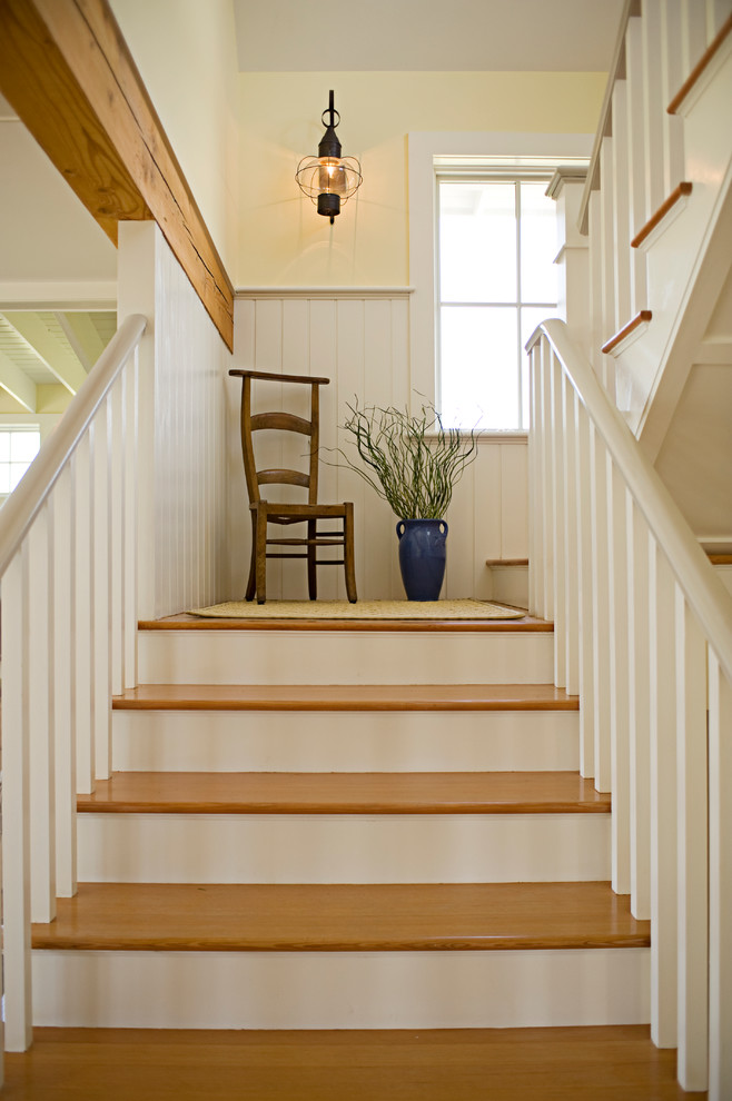 Стильный дизайн: п-образная лестница в морском стиле с деревянными ступенями и крашенными деревянными подступенками - последний тренд