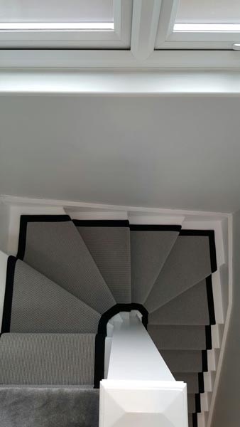 Photo of a medium sized traditional carpeted u-shaped mixed railing staircase in London.
