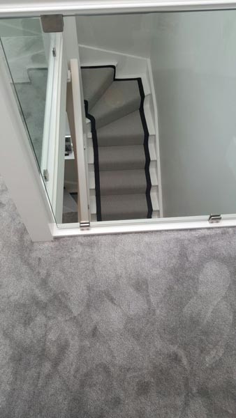 ロンドンにある中くらいなトランジショナルスタイルのおしゃれな折り返し階段 (混合材の手すり) の写真