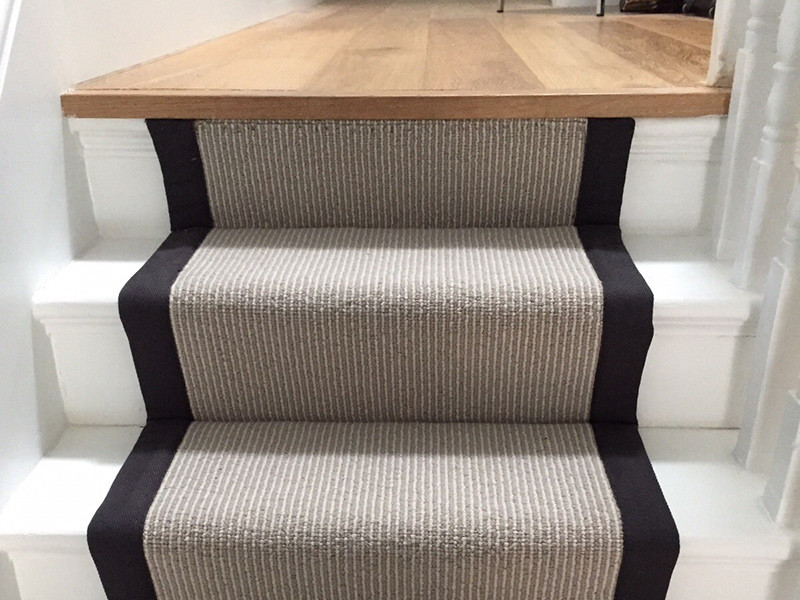 This is an example of a classic carpeted u-shaped wood railing staircase in London with carpeted risers.
