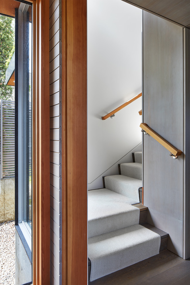Источник вдохновения для домашнего уюта: маленькая угловая лестница в стиле модернизм с ступенями с ковровым покрытием, ковровыми подступенками и деревянными перилами для на участке и в саду