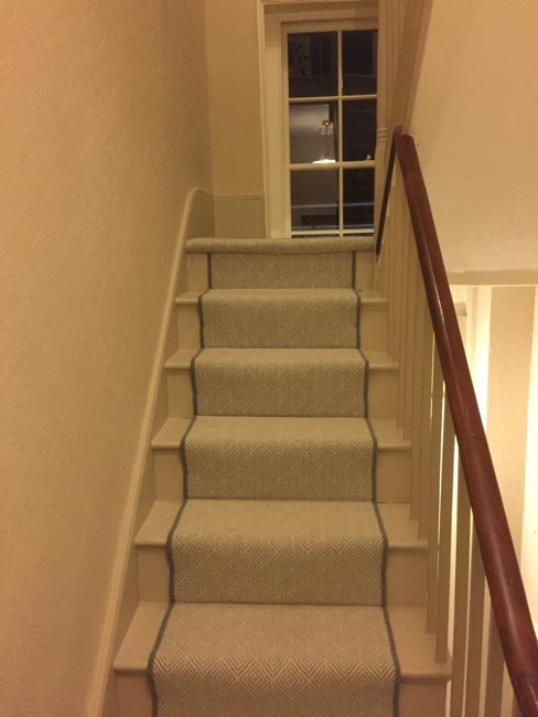 Design ideas for a contemporary carpeted u-shaped wood railing staircase in London with carpeted risers.