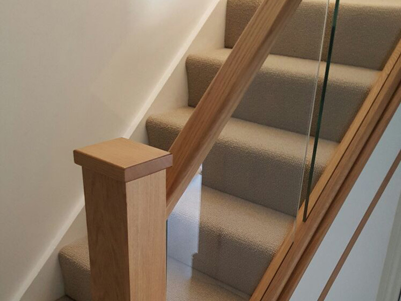 ロンドンにあるトランジショナルスタイルのおしゃれな折り返し階段 (混合材の手すり) の写真