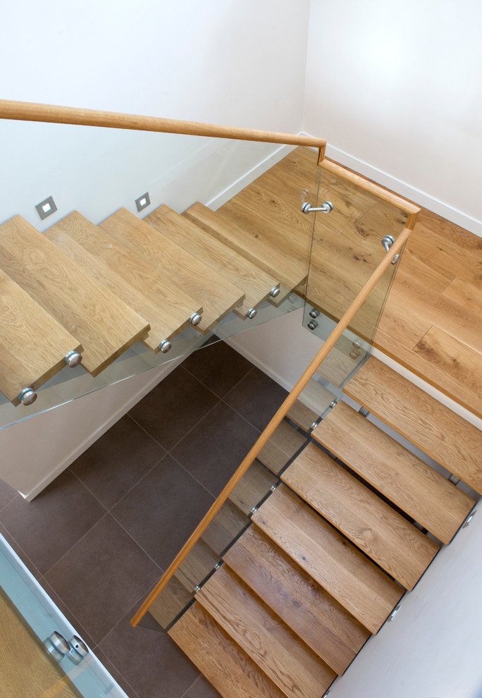 Идея дизайна: п-образная металлическая лестница среднего размера в современном стиле с деревянными ступенями и стеклянными перилами