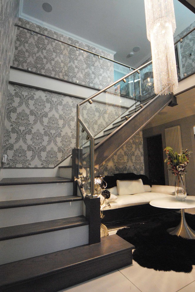 Large contemporary wood l-shaped metal railing staircase in Cheshire with painted wood risers.