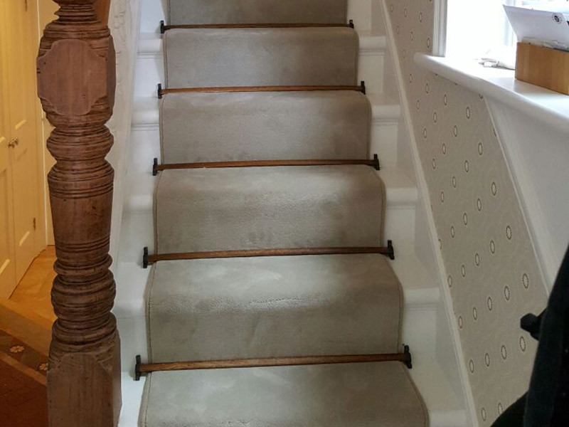 Foto de escalera en U clásica de tamaño medio con escalones enmoquetados, contrahuellas enmoquetadas y barandilla de madera