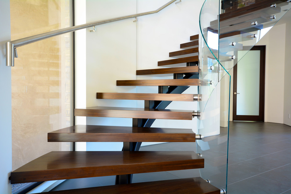 Example of a minimalist wooden curved open staircase design in Los Angeles