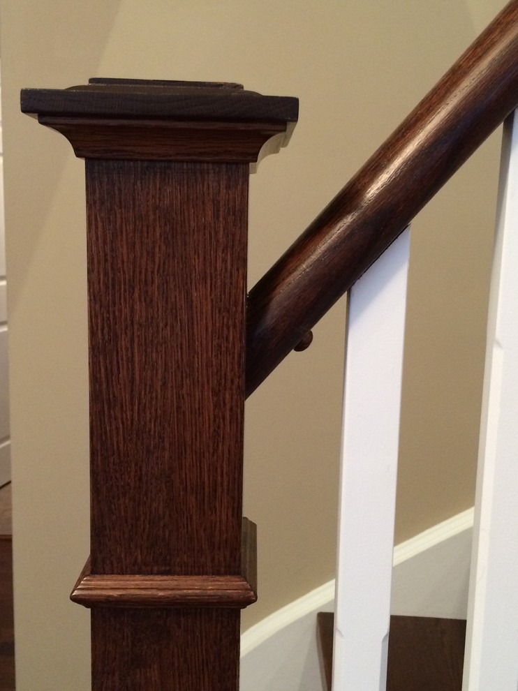 Large traditional wood curved staircase in Toronto with painted wood risers.