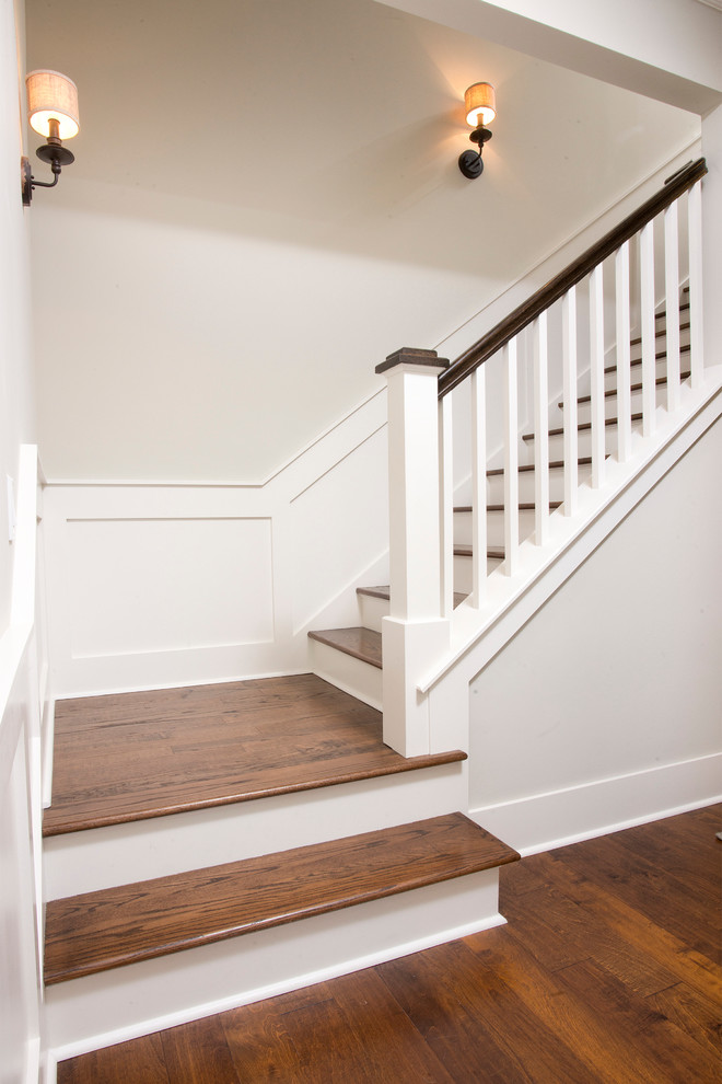 Ejemplo de escalera en L clásica renovada de tamaño medio con escalones de madera, contrahuellas de madera pintada y barandilla de madera