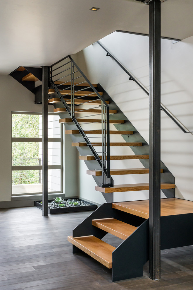 This is an example of a large modern wood floating staircase in Other with open risers.