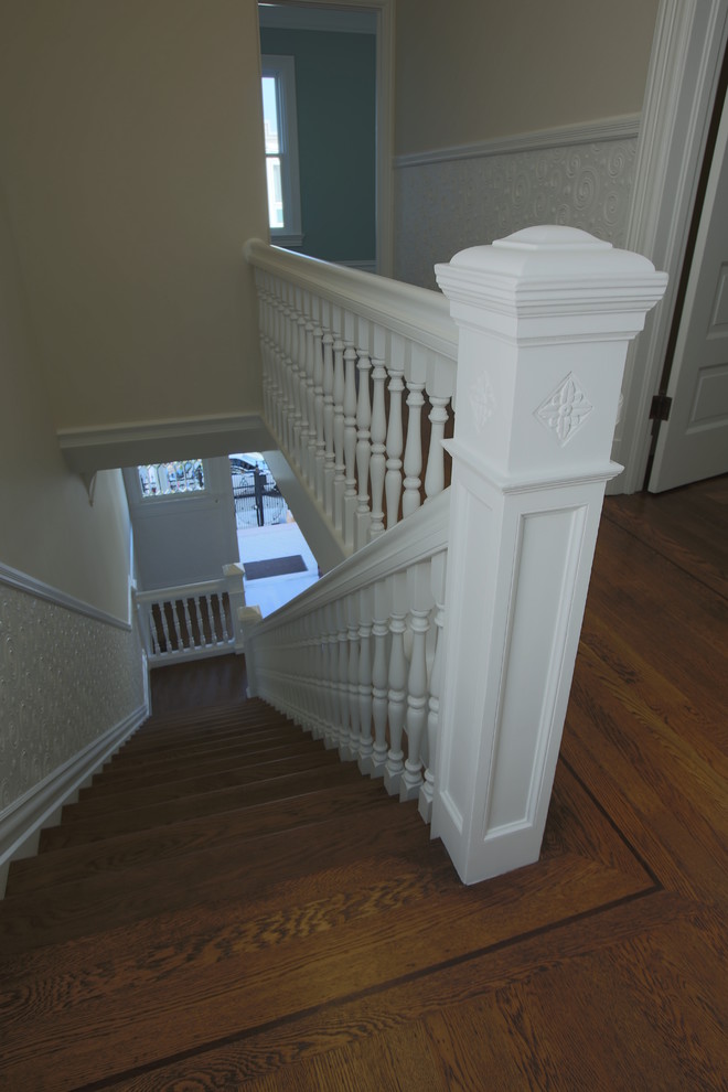 This is an example of a medium sized classic wood straight staircase in San Francisco with painted wood risers.
