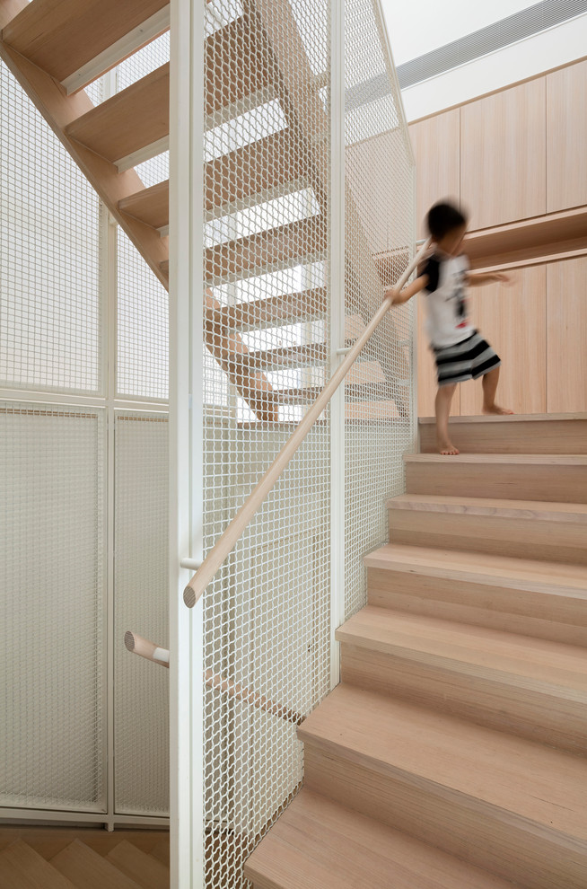 На фото: п-образная деревянная лестница в скандинавском стиле с деревянными ступенями с