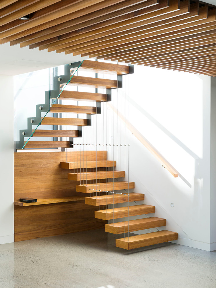На фото: большая лестница на больцах в современном стиле с деревянными ступенями без подступенок