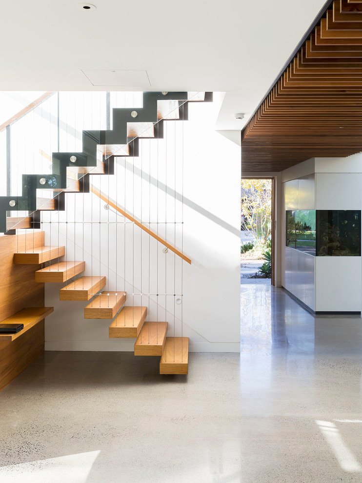 Diseño de escalera suspendida actual grande sin contrahuella con escalones de madera