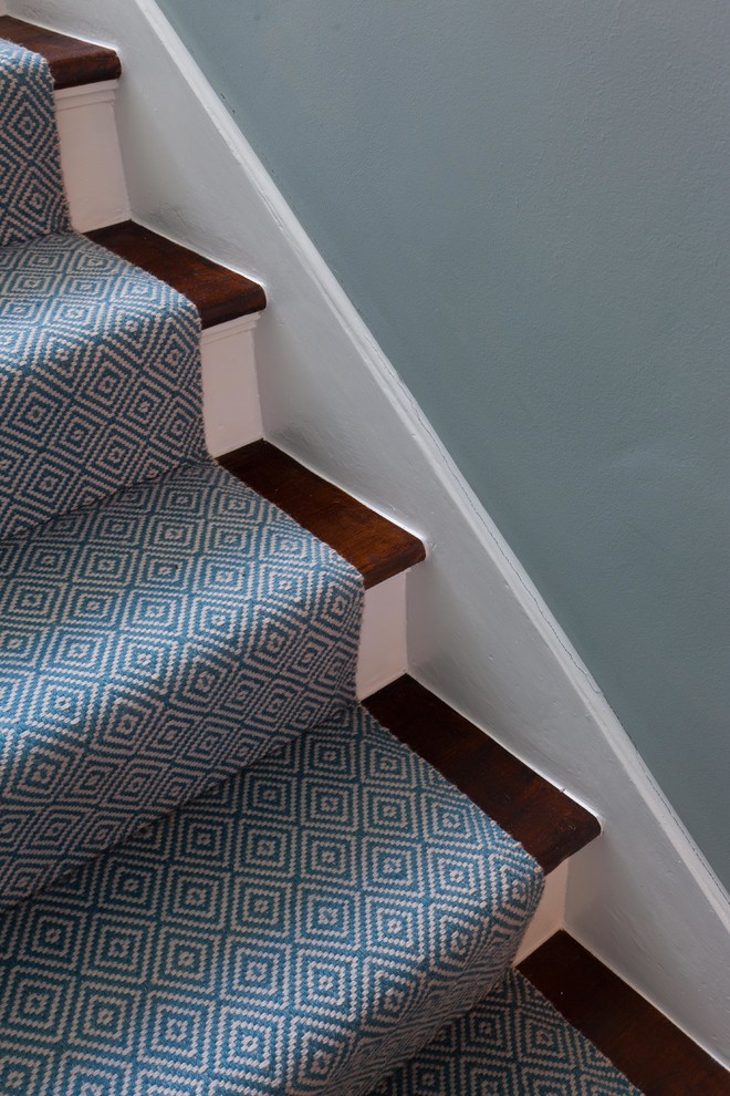 Imagen de escalera curva actual pequeña con escalones de madera, contrahuellas de madera pintada y barandilla de madera