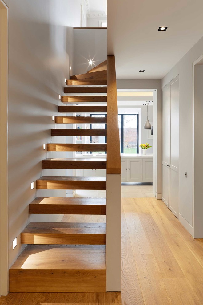 Modern wood curved staircase in London with wood risers.