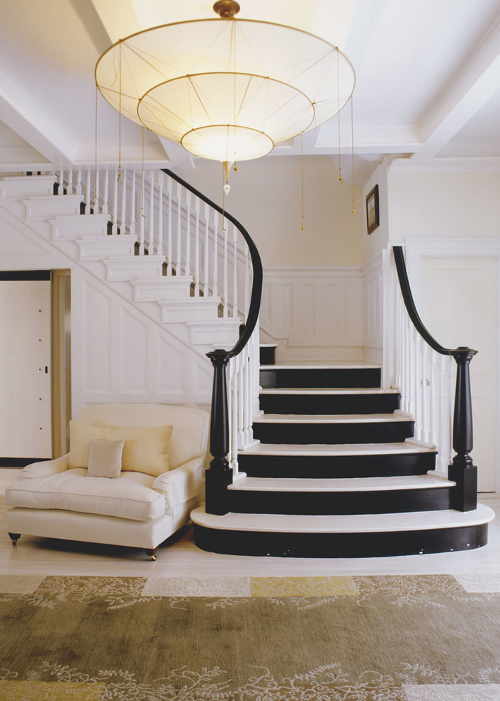 На фото: изогнутая лестница среднего размера в современном стиле с крашенными деревянными ступенями и крашенными деревянными подступенками