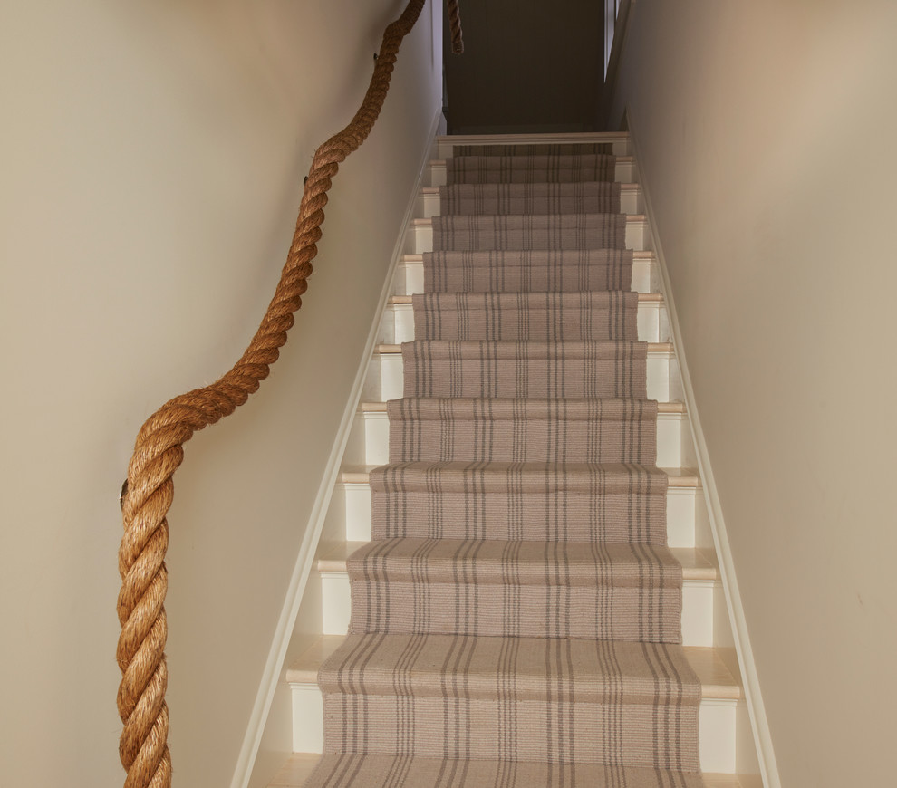 This is an example of a medium sized coastal carpeted straight staircase in New York with carpeted risers.