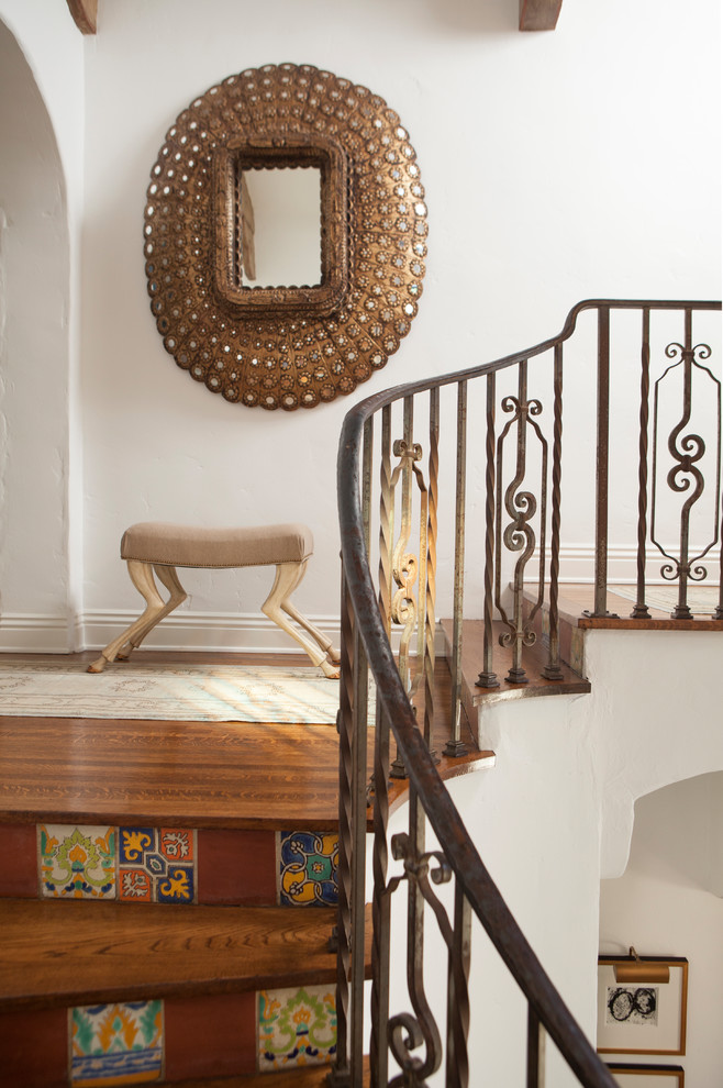 Idée de décoration pour un escalier méditerranéen avec des marches en bois, des contremarches carrelées et un garde-corps en métal.