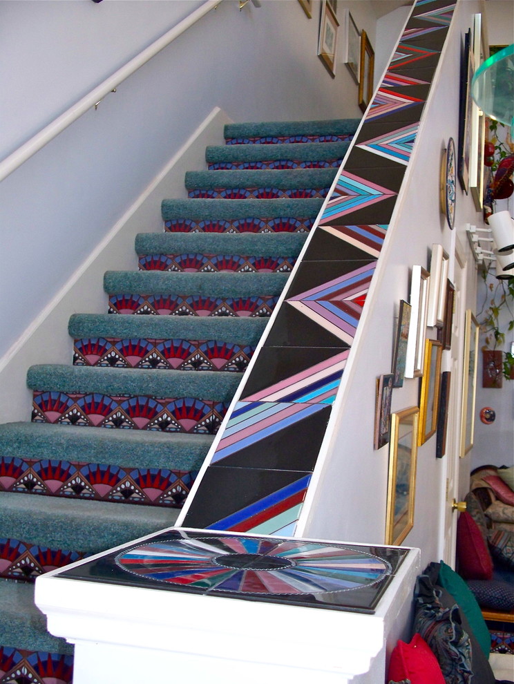 На фото: лестница в стиле модернизм с ступенями с ковровым покрытием и подступенками из плитки с