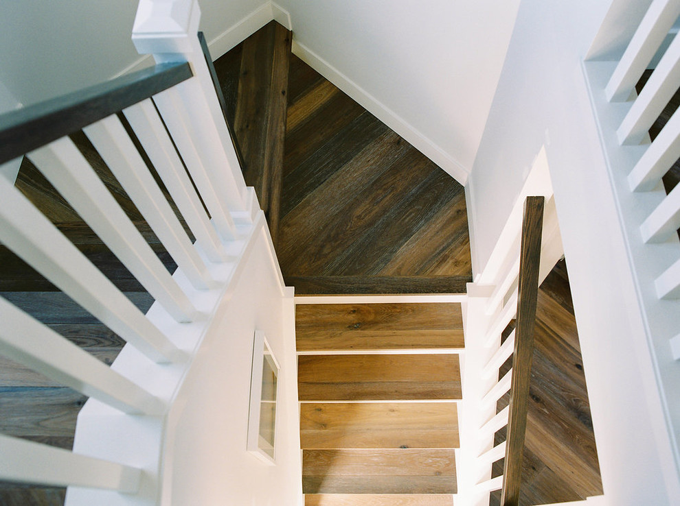 Diseño de escalera en U campestre de tamaño medio con escalones de madera, contrahuellas de madera pintada y barandilla de madera