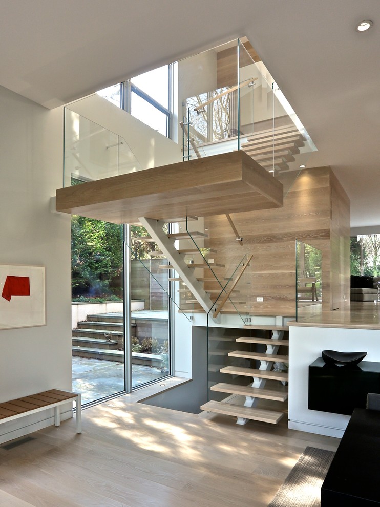 This is an example of a contemporary wood u-shaped staircase in New York with open risers.