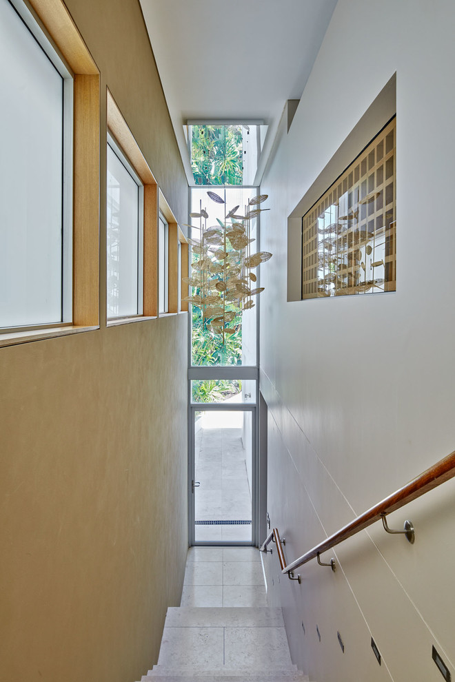 Свежая идея для дизайна: прямая лестница среднего размера в современном стиле с деревянными перилами и ступенями из известняка - отличное фото интерьера