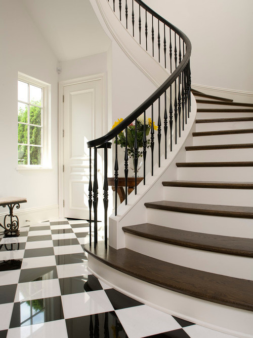 Idée de décoration pour un escalier peint courbe tradition de taille moyenne avec des marches en bois et un garde-corps en bois.