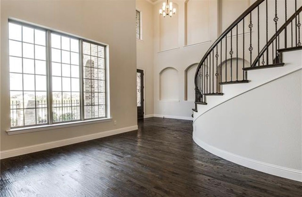 This is an example of a large classic wood curved mixed railing staircase in Dallas with wood risers.