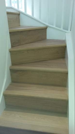 ロンドンにあるコンテンポラリースタイルのおしゃれなかね折れ階段 (木の蹴込み板、木材の手すり) の写真