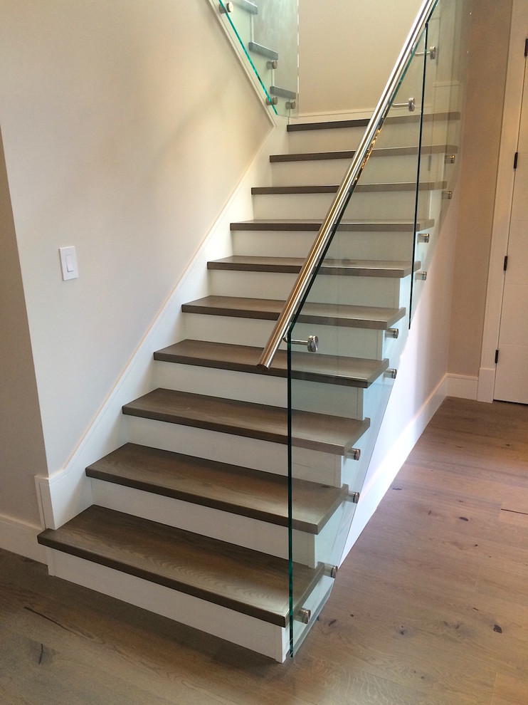 Ejemplo de escalera en L contemporánea de tamaño medio con escalones de madera, contrahuellas de madera y barandilla de metal